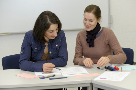 Zwei Frauen im Schreibkurs mit Schreibmaterialien