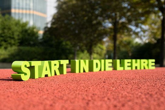 Schriftzug „Start in die Lehre“ auf einer Tartanbahn