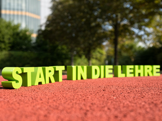 Schriftzug „Start in die Lehre“ auf einer Tartanbahn