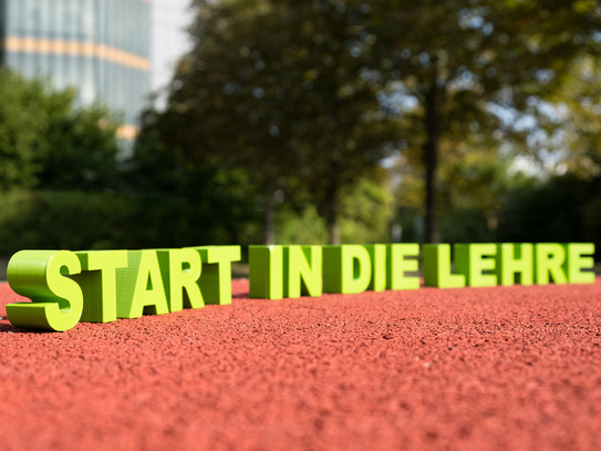 Schriftzug „Start in die Lehre“ auf einer Tartanbahn