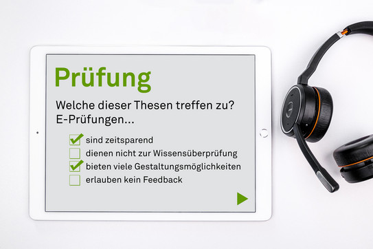 Tablet mit einem Online-Test, daneben liegt ein Kopfhörer