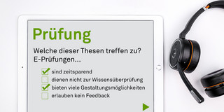Tablet mit einem Online-Test, daneben liegt ein Kopfhörer