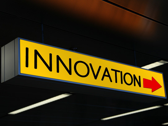 Foto: ein gelbes Schild mit dem Schriftzug "Innovation" und einem roten Pfeil daneben