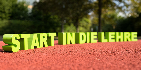 Schriftzug „Start in die Lehre“ auf einer Tartanbahn