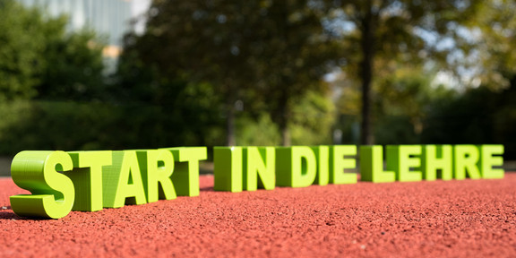 Schriftzug „Start in die Lehre“ auf einer Tartanbahn