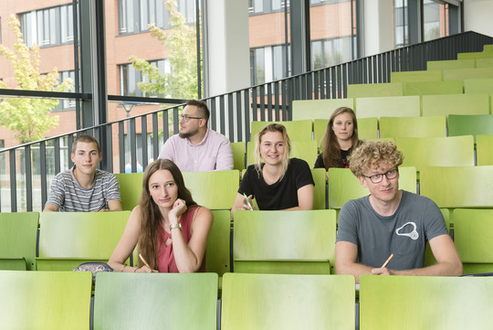 A group of students is sitting in a lecture hall