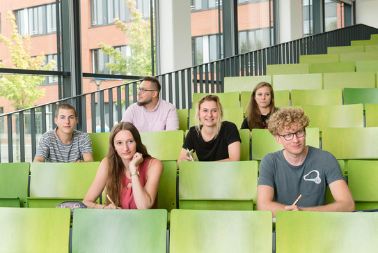 A group of students are sitting in a lecture hall.