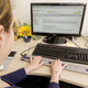 Eine blinde Studentin sitzt an einem PC und lernt mit der ALVA Tastatur.